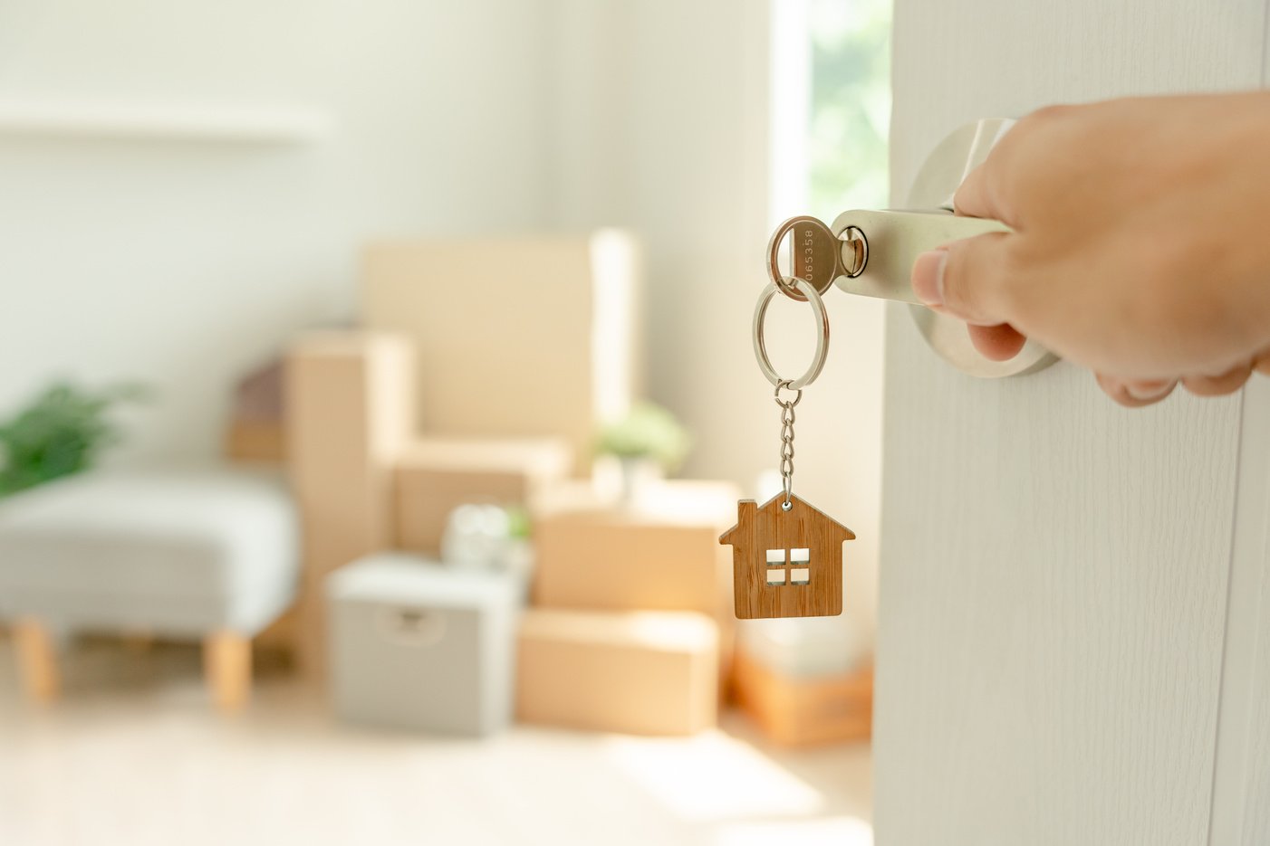 Moving house, relocation. Man hold key house keychain in new apa